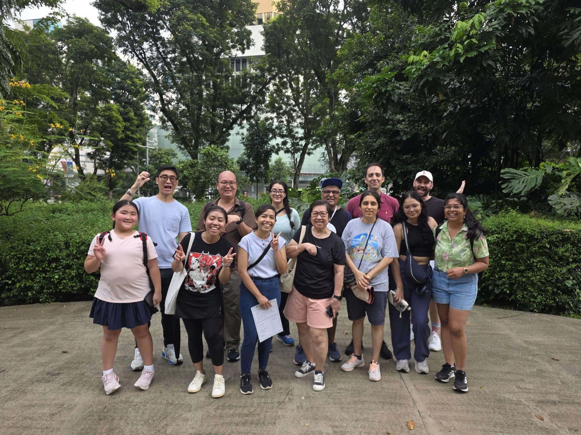 A group of walk participants gathered on a path surrounded by greenery